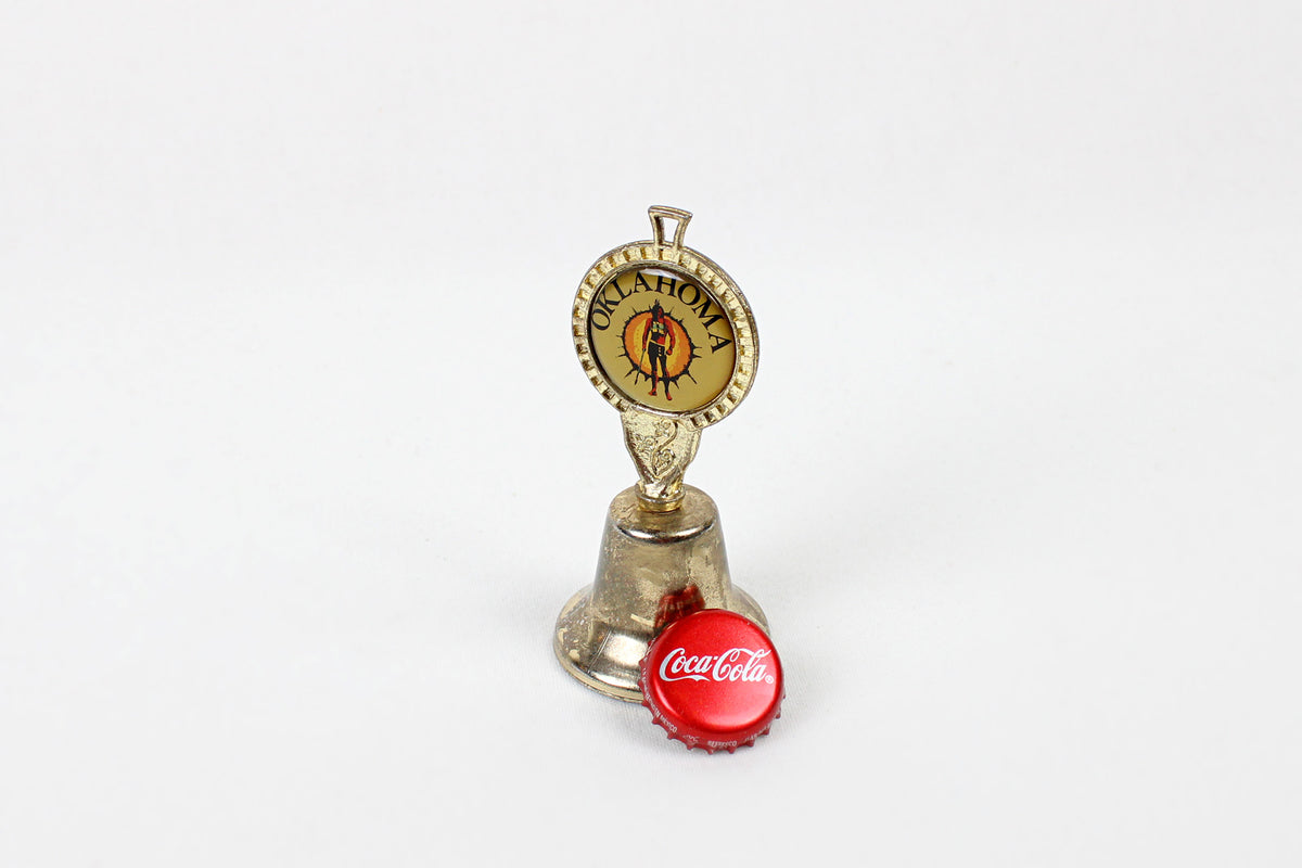 Oklahoma Metal Bell With Emblem Of Indian Warrior Against A Sun Symbol