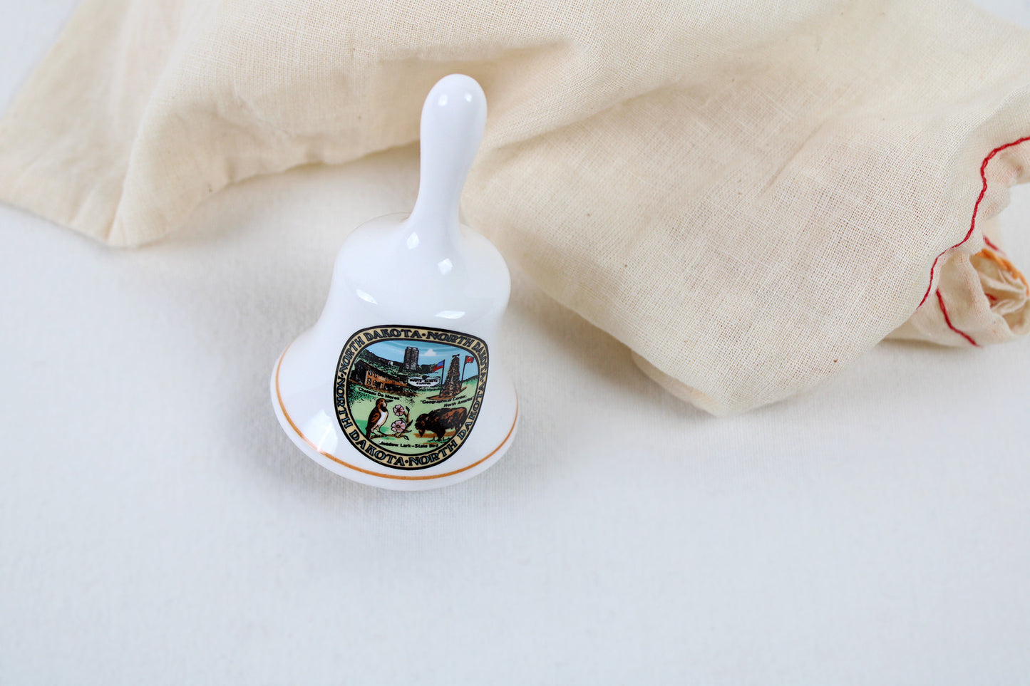 North Dakota Ceramic Souvenir Bell With State Emblems And Sites