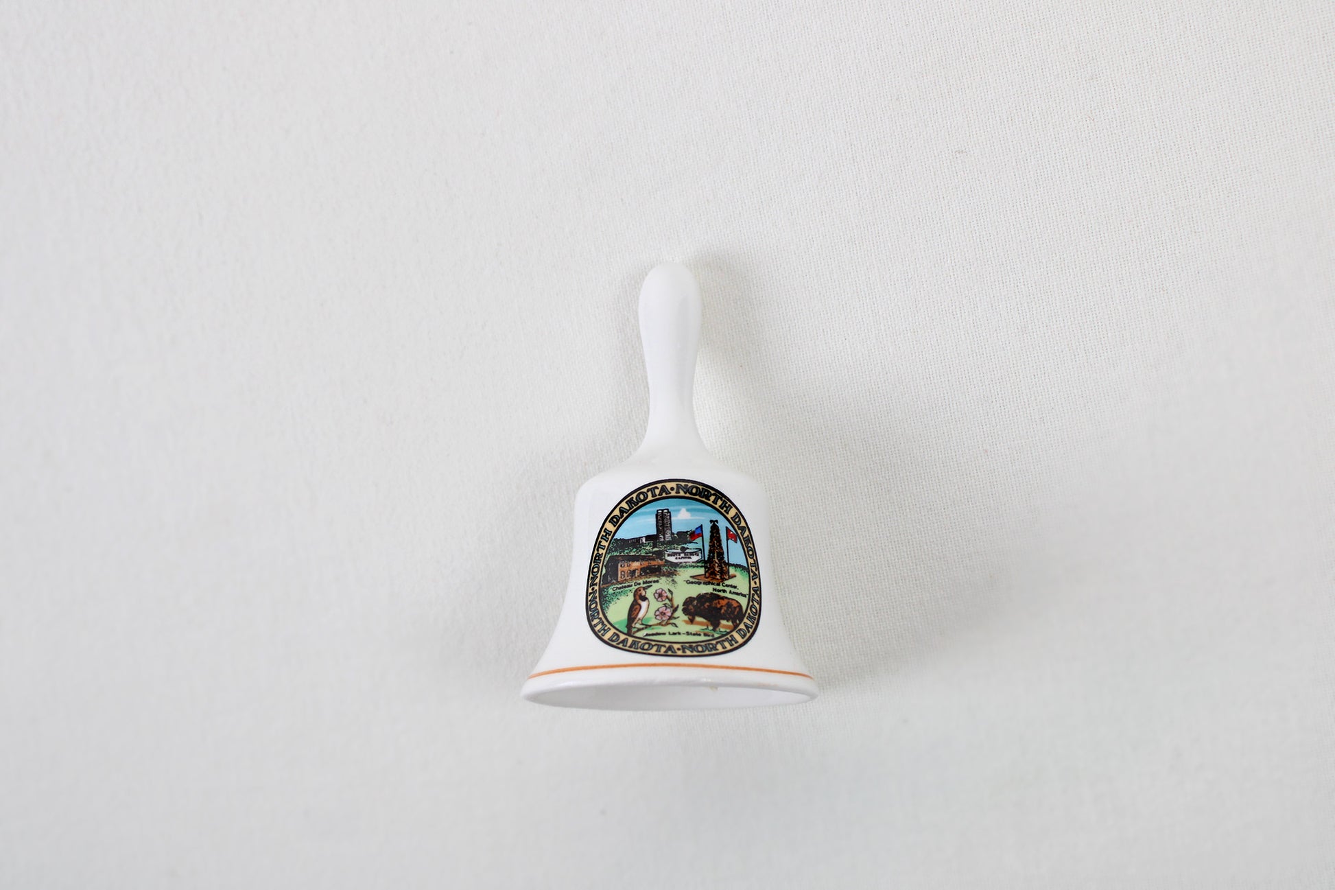 North Dakota Ceramic Souvenir Bell With State Emblems And Sites